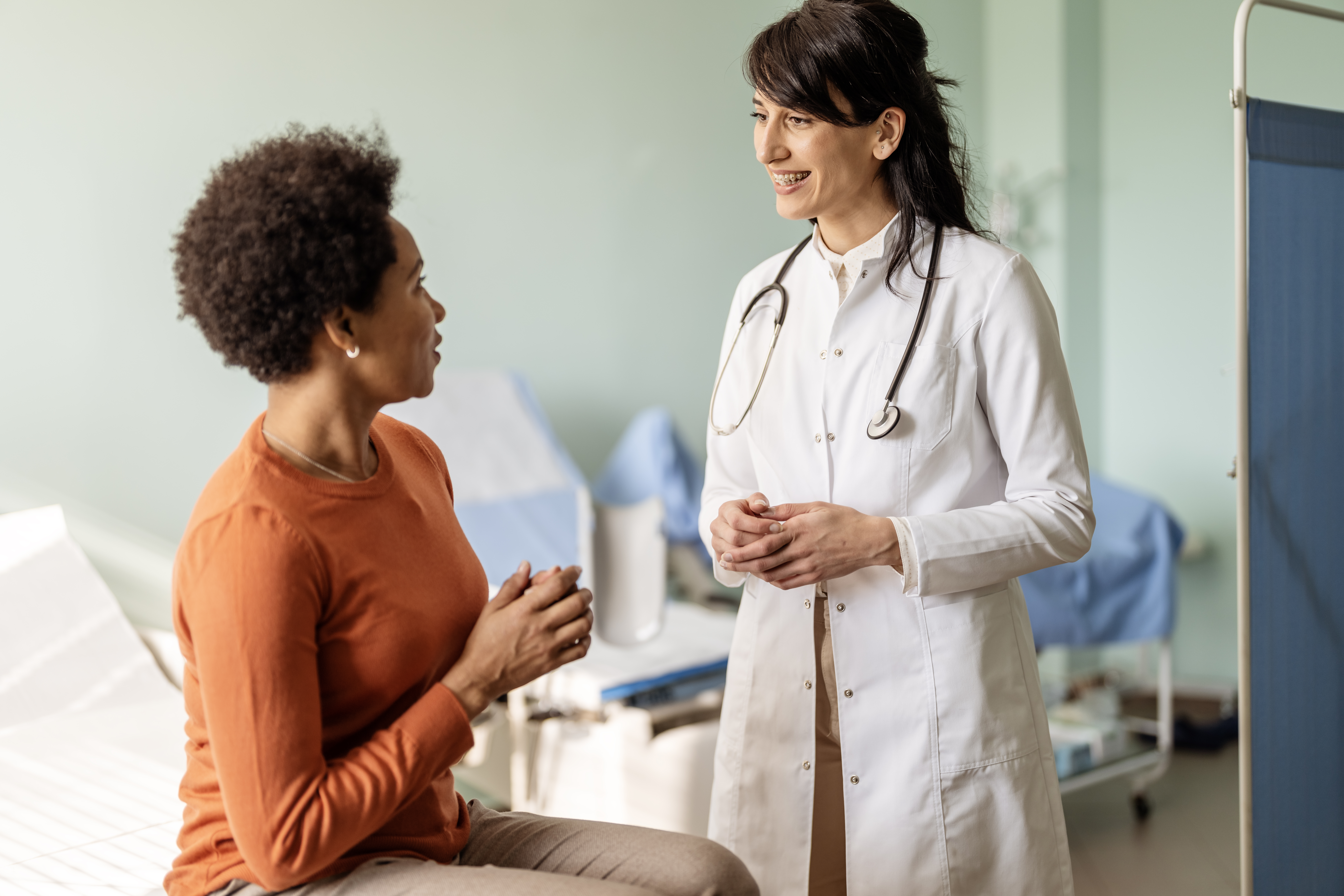 Female patient is explaining her problems as the doctor listens intently.