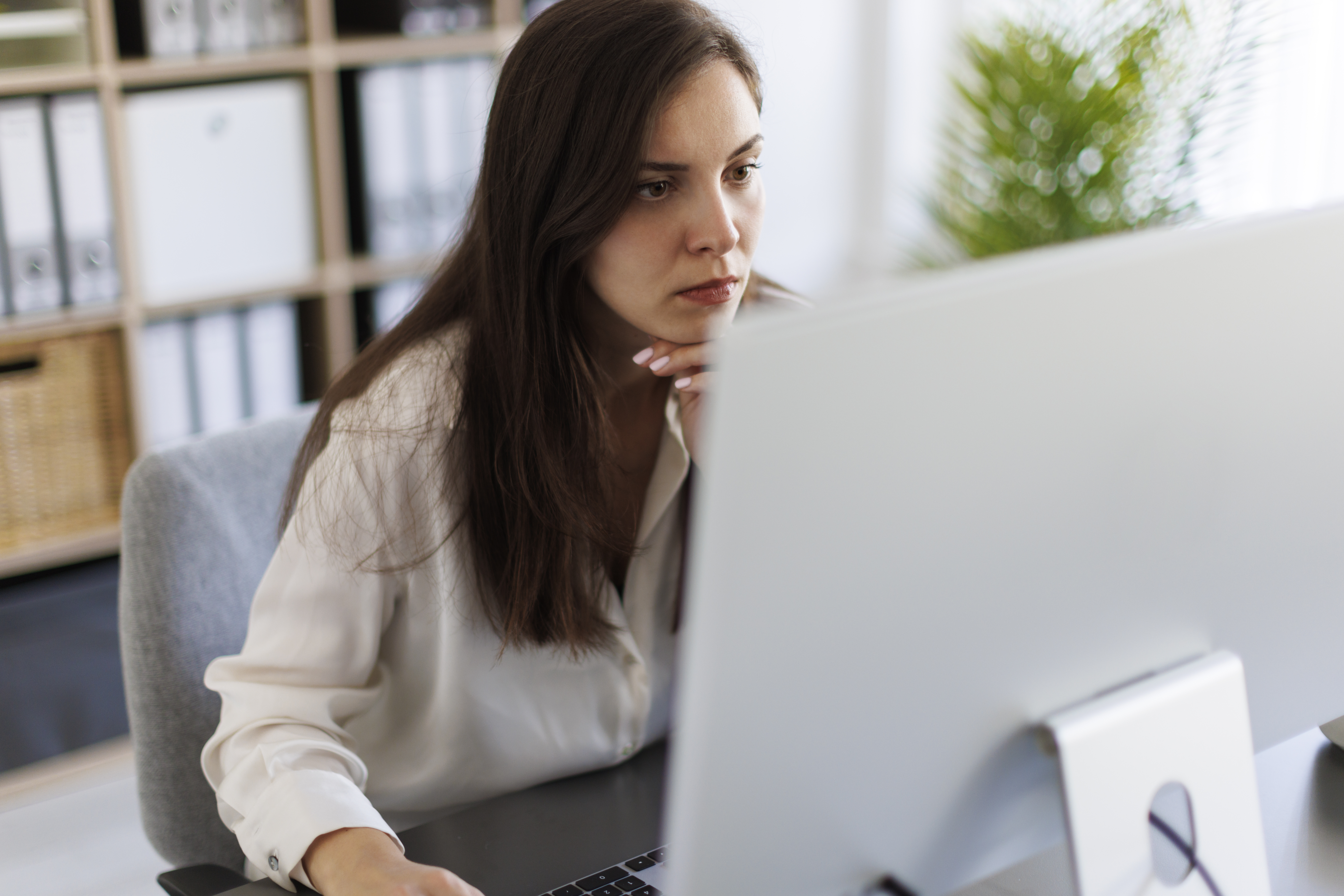Thoughtful businesswoman working on computer in the office